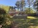 A fenced backyard featuring a two-story home with an expansive deck, surrounded by mature trees offering privacy at 509 E Millbrook Rd, Raleigh, NC 27609