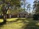 A backyard featuring a lush lawn, mature trees, and a spacious wooden deck perfect for outdoor entertaining and relaxation at 509 E Millbrook Rd, Raleigh, NC 27609