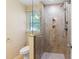 Bathroom featuring a glass enclosed shower, tile surround, and a window providing natural light at 509 E Millbrook Rd, Raleigh, NC 27609