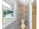 Bright bathroom with patterned wallpaper, window, toilet, and open door to tiled shower at 509 E Millbrook Rd, Raleigh, NC 27609