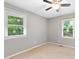 Bright bedroom with neutral walls, carpet, and two windows offering ample natural light at 509 E Millbrook Rd, Raleigh, NC 27609