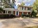 A charming two-story home with a brick facade and a well-maintained front yard on a sunny day at 509 E Millbrook Rd, Raleigh, NC 27609