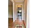 Hallway with hardwood floors featuring a rug and an open doorway providing a view into the kitchen at 509 E Millbrook Rd, Raleigh, NC 27609