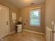 Bright laundry room featuring tile flooring, a window, and a door to the exterior at 509 E Millbrook Rd, Raleigh, NC 27609