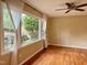 Bright living room with hardwood floors, ceiling fan, and large window with sheer curtains at 509 E Millbrook Rd, Raleigh, NC 27609