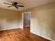 Living room with ceiling fan and hardwood floors, with a doorway opening to another room at 509 E Millbrook Rd, Raleigh, NC 27609