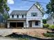 New two-story home featuring an attached two-car garage, a front door with a covered porch, and multiple windows at 521 Peebles St, Raleigh, NC 27608