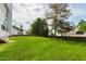 Expansive backyard with lush green grass, a privacy fence, and mature trees at 5416 Whisperwood Dr, Durham, NC 27713
