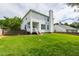 View of the home's exterior and expansive backyard with lush green lawn and mature trees at 5416 Whisperwood Dr, Durham, NC 27713