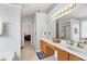 Well-lit bathroom with double sinks, spacious counters, and a bright mirror providing ample grooming space at 5416 Whisperwood Dr, Durham, NC 27713