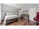 Well-lit bedroom with wood floors, a comfortable bed, and a wood dresser with mirror at 5416 Whisperwood Dr, Durham, NC 27713