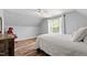 Bright bedroom with wood floors, ceiling fan, and a large window offering a scenic view at 5416 Whisperwood Dr, Durham, NC 27713