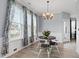 Cozy dining room with a chandelier, hardwood floors, and large windows at 5416 Whisperwood Dr, Durham, NC 27713
