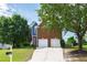 Charming two-story brick home with a well-manicured lawn, attached garage, and beautiful landscaping at 5416 Whisperwood Dr, Durham, NC 27713