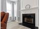 Close-up of a fireplace with white trim, a black hearth, and natural light from the windows at 5416 Whisperwood Dr, Durham, NC 27713