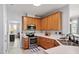 Well-lit kitchen features stainless appliances, wood cabinets, and a double sink at 5416 Whisperwood Dr, Durham, NC 27713
