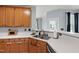 Well-maintained kitchen with wooden cabinetry, white countertops, and a double sink at 5416 Whisperwood Dr, Durham, NC 27713