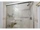 Shower with glass doors, shower head and seat inside and beige tile walls, for a luxurious experience at 5416 Whisperwood Dr, Durham, NC 27713
