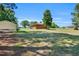 Spacious backyard with a brick home, bordered with green trees, under a sunny blue sky at 585 Cokesbury Rd, Fuquay Varina, NC 27526