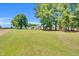 Expansive green lawn with trees, offering a serene outdoor space and featuring a detached garage at 585 Cokesbury Rd, Fuquay Varina, NC 27526