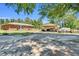 View of the brick home with an open detached garage, surrounded by a spacious yard with plenty of room for parking at 585 Cokesbury Rd, Fuquay Varina, NC 27526