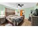 Comfortable bedroom with a wooden bed frame, hardwood floors, ceiling fan, and neutral-toned walls at 585 Cokesbury Rd, Fuquay Varina, NC 27526