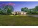 Charming brick ranch-style home with well-manicured lawn and mature trees against a beautiful colorful sunset sky at 585 Cokesbury Rd, Fuquay Varina, NC 27526