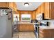 Bright kitchen showcasing modern stainless steel appliances and ample wooden cabinetry at 585 Cokesbury Rd, Fuquay Varina, NC 27526