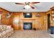 Comfortable living room includes wood paneling, a fireplace, and mounted television at 585 Cokesbury Rd, Fuquay Varina, NC 27526