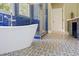 Beautiful bathroom showcasing a soaking tub, a blue tiled shower, and elegant patterned floors at 639 Cedar Grove Rd, Pittsboro, NC 27312