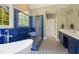 Stunning bathroom with a soaking tub, blue hexagon tile shower, and patterned floor at 639 Cedar Grove Rd, Pittsboro, NC 27312