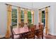 Bright dining room featuring a wood table, six chairs, yellow floral draperies, and hardwood floors at 639 Cedar Grove Rd, Pittsboro, NC 27312
