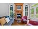 Relaxing living room featuring a brick fireplace, light grey walls, hardwood floors, and blue accents at 639 Cedar Grove Rd, Pittsboro, NC 27312