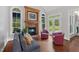 Relaxing living room featuring a brick fireplace, light grey walls, hardwood floors, and blue accents at 639 Cedar Grove Rd, Pittsboro, NC 27312