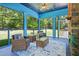 Relaxing screened-in porch with wicker furniture, a stone fireplace, and serene views of the backyard at 639 Cedar Grove Rd, Pittsboro, NC 27312