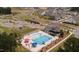 Overhead shot of community amenities including a pool, playground, clubhouse, parking and roundabout in a neighborhood of homes at 646 Shelford Trl, Zebulon, NC 27597