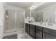 A bathroom featuring a glass shower, dual vanity with dark cabinets and a large mirror at 646 Shelford Trl, Zebulon, NC 27597