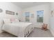 A bedroom with white furnishings and two windows and light carpet and a toddler rocking chair at 646 Shelford Trl, Zebulon, NC 27597