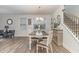 Charming dining area featuring a wood table, modern chandelier, and staircase at 646 Shelford Trl, Zebulon, NC 27597