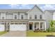 Exterior of a two-story townhome featuring a stone-accented garage and inviting front porch at 646 Shelford Trl, Zebulon, NC 27597