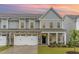 Exterior of a two-story townhome with stone accents, well-maintained lawn, and inviting porch seating at 646 Shelford Trl, Zebulon, NC 27597
