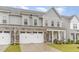 Exterior view of a two-story townhome featuring a stone-accented garage and inviting front porch at 646 Shelford Trl, Zebulon, NC 27597
