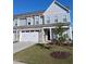 Charming two-story townhome featuring a two-car garage, stone accents, and a well-manicured lawn with beautiful landscaping at 646 Shelford Trl, Zebulon, NC 27597