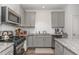 A close up view of a modern kitchen with stainless steel appliances and granite counters and white subway tile at 646 Shelford Trl, Zebulon, NC 27597