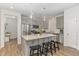 A modern kitchen with gray cabinets, stainless steel appliances, an island with barstool seating and granite counters at 646 Shelford Trl, Zebulon, NC 27597