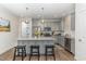 A modern kitchen with gray cabinets, stainless steel appliances, an island with barstool seating and granite counters at 646 Shelford Trl, Zebulon, NC 27597