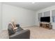 Living room features a sofa, media cabinet, and neutral carpet at 646 Shelford Trl, Zebulon, NC 27597