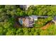 Aerial view of a home with a pool, a sprawling lawn, and surrounded by mature trees at 7116 Dumfries Ln, Chapel Hill, NC 27514