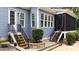 Charming home exterior with stairs to a screened porch and a yard with lush landscaping and stonework at 7116 Dumfries Ln, Chapel Hill, NC 27514