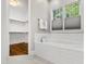 Modern white bathtub with tile surround, next to window and walk-in closet at 7116 Dumfries Ln, Chapel Hill, NC 27514